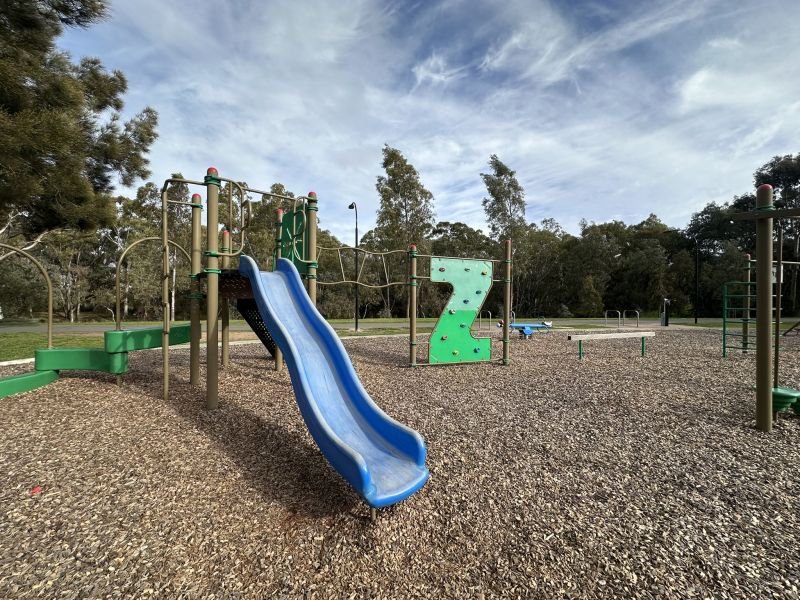 Image of play structure with slide, rock climbing and agility play
